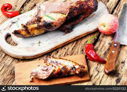 grilled duck with apples. roast duck and apples on a wooden cutting board
