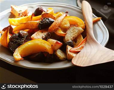 Grilled fall seasonal vegetables on plate over a dark background .. Grilled fall seasonal vegetables on plate over a dark background