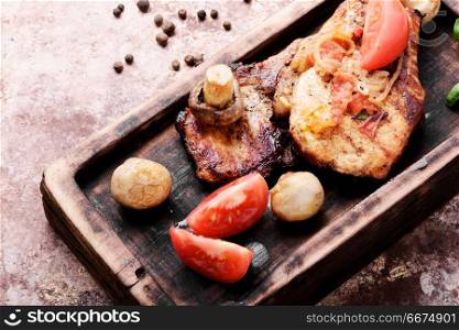 Grilled fillet steak. Grilled meat steak,tomato, herbs and spices on cutting board.Bbq meat