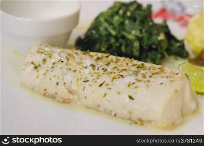 grilled fish. close up white fish steak with vegetable on white plate