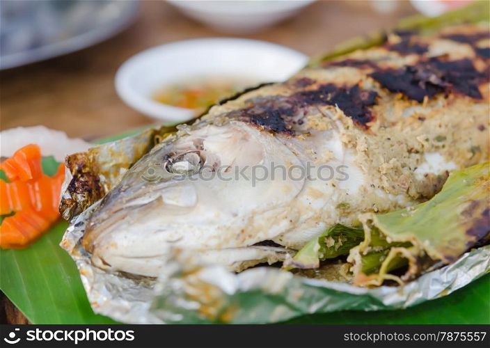 grilled fish. Grilled fish on green banana leaf with herbs