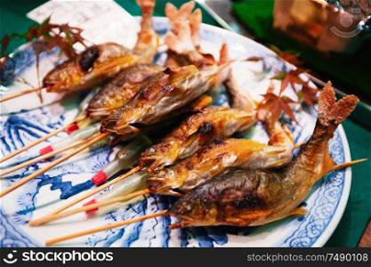 Grilled fishes on sticks as street food at Nishiki market in Kyoto, Japan.. Grilled fishes on sticks as street food at Nishiki market, Kyoto