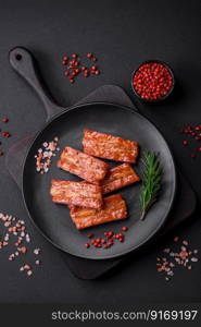 Grilled fresh juicy ribs with salt, spices and herbs on a dark concrete background