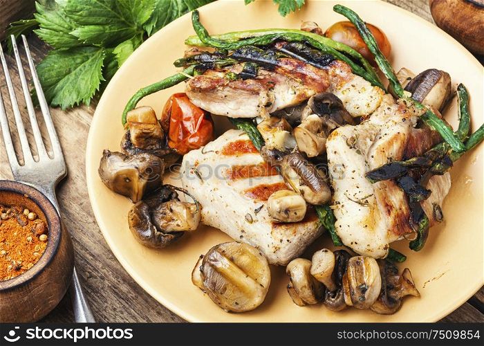Grilled juicy steak with mushrooms on a plate. Delicious grilled meat