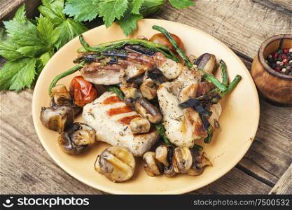 Grilled juicy steak with mushrooms on a plate. Grilled meat on rustic wooden table
