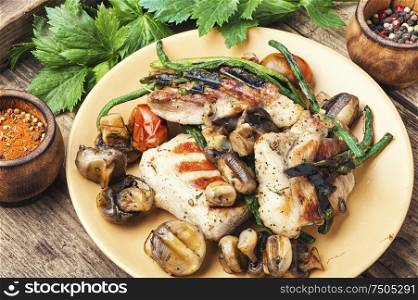 Grilled juicy steak with mushrooms on plate.Meat food. Grilled meat on rustic wooden table