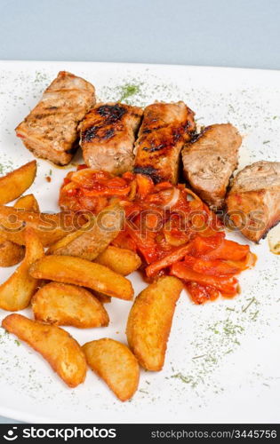 Grilled kebab pork meat with roasted potato and vegetables