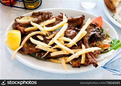 Grilled lamb ribs with potatoes on a large plate