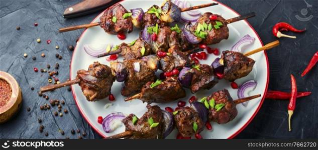 Grilled liver kebab with onion on wooden skewers. Grilled liver barbecue skewer