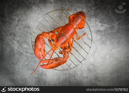 Grilled lobster on grill on the dark background / red lobster food on dining table , top view