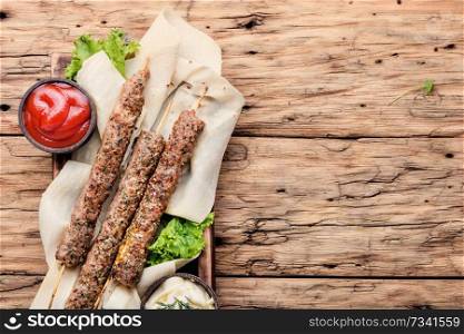 Grilled Lula kebab lamb with sauce.Traditional oriental cuisine.. Shish kebab on a stick