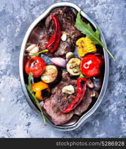 Grilled meat and vegetables. Beef fried meat, grilled vegetables on a plate