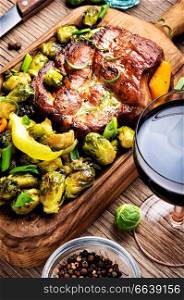 Grilled meat barbecue steak and red wine.Grilled meat and vegetable garnish. Meat steak and a glass of wine