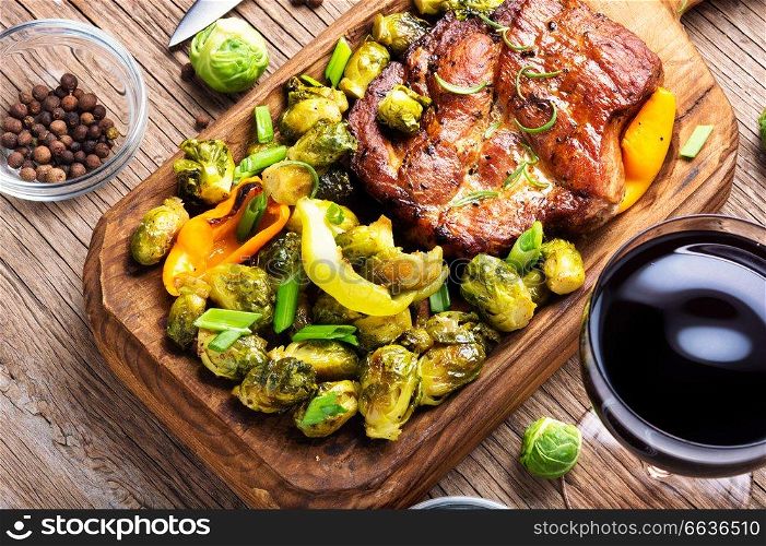 Grilled meat barbecue steak with brussels sprouts.Grilled meat and vegetable garnish. Dinner with steaks and red wine