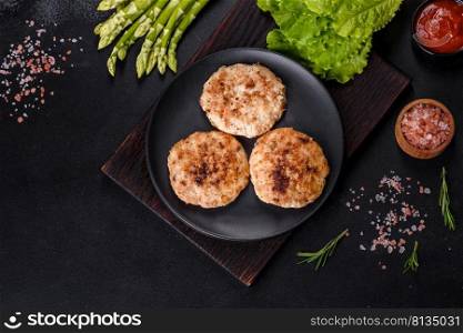 Grilled meat cutlets. Cutlets for burger. Top view. Free space for your text. Flat lay composition with grilled meat cutlets for burger on black concrete table