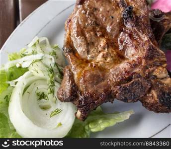 grilled meat in plate on a wooden table