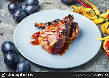 Grilled meat on plate. Grilled meat with autumn plum.Bbq. Grilled meat in plum sauce