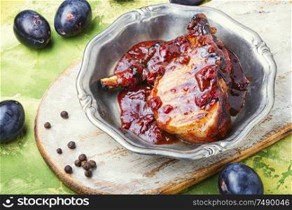 Grilled meat on plate. Grilled meat with autumn plum.Bbq. Grilled meat in plum sauce