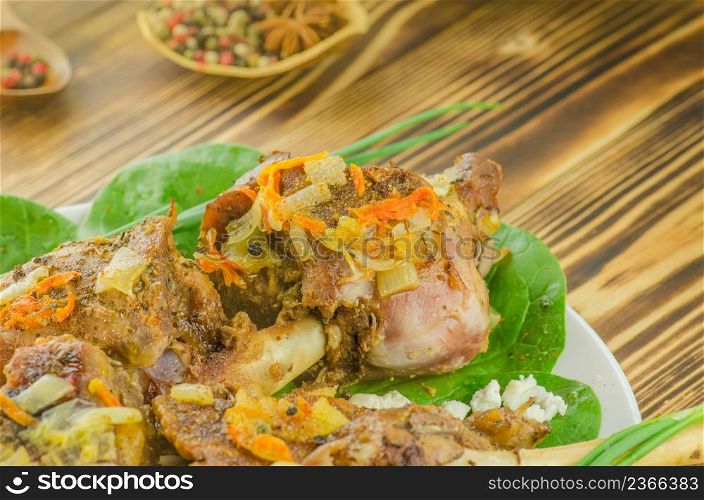 Grilled meat ribs on white plate. Closeup on chopping freshly baked meat. Baked meat with vegetables and greens