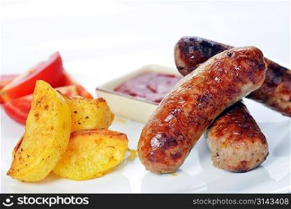 grilled meat sausages with potatoes and tomatoes