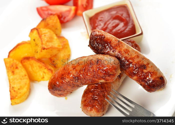 grilled meat sausages with potatoes and tomatoes