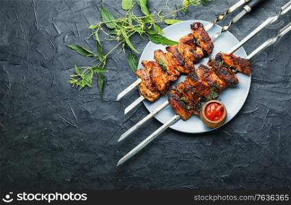 Grilled meat skewers or shish kebab pickled in nettle foliage. Kebab marinated in nettles