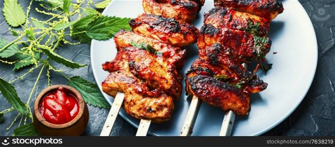 Grilled meat skewers or shish kebab pickled in nettle foliage. Kebabs,grilled meat with nettles