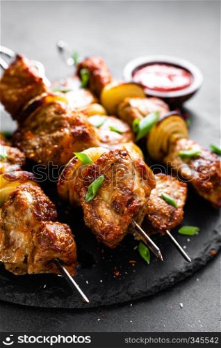 Grilled meat skewers, shish kebab on black background