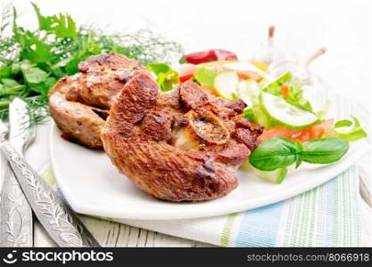 Grilled meat turkey in a white plate with slices of tomato, cucumber and sweet pepper on the background of wooden boards