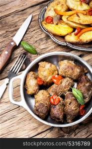 Grilled meat with boiled potatoes. Juicy meatloaf with baked potatoes in a rustic way