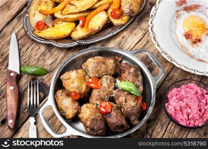 Grilled meat with boiled potatoes. Juicy meatloaf with baked potatoes in a rustic way