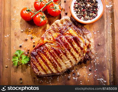 grilled meat with vegetables on wooden board, top view