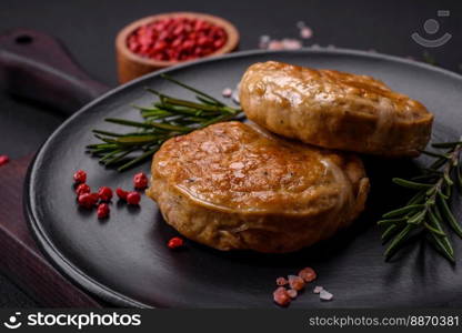 Grilled meatballs with spices and herbs or crepinette on a dark concrete background