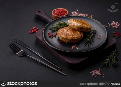 Grilled meatballs with spices and herbs or crepinette on a dark concrete background