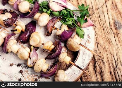Grilled mushrooms on wooden skewers. Vegetable shish kebab.Roasted mushrooms. Vegetable kebab with mushrooms