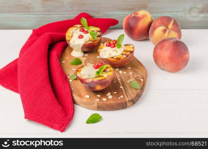 Grilled peaches with yogurt, gooseberries and mint leaves on wooden table