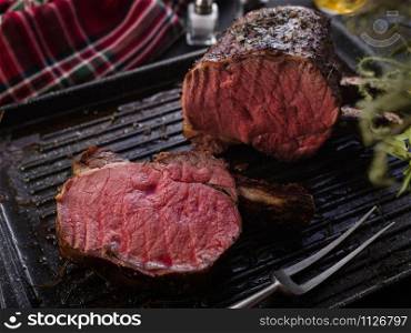 Grilled piece of meat with bone in a grill pan. Fried steak. Roasting - Medium Rare.