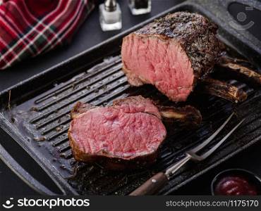 Grilled piece of meat with bone in a grill pan. Fried steak. Roasting - Medium Rare.
