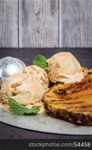 Grilled pineapple with vanilla ice cream and mint leaves