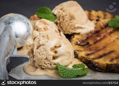 Grilled pineapple with vanilla ice cream and mint leaves