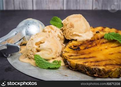 Grilled pineapple with vanilla ice cream and mint leaves