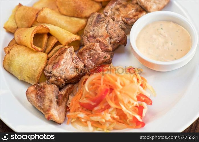 Grilled pork, baked potatoes and vegetable salad