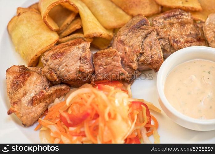 Grilled pork, baked potatoes and vegetable salad