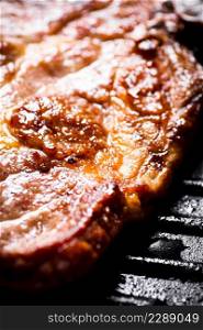 Grilled pork steak in a frying pan. Macro background. High quality photo. Grilled pork steak in a frying pan. Macro background.