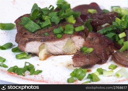 Grilled pork steak on white plate.