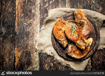 Grilled pork steak with spices. On wooden background.. Grilled pork steak with spices.