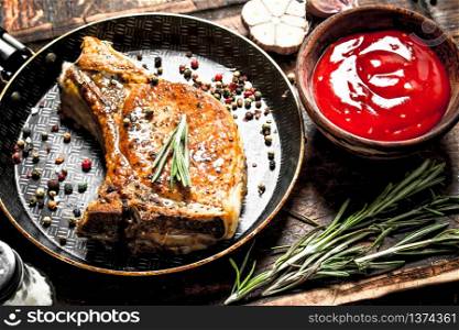 Grilled pork steak with tomato sauce. On wooden background.. Grilled pork steak with tomato sauce.