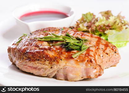 Grilled pork steaks with raspberry sauce, rosemary and leaf of lettuce