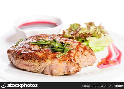 Grilled pork steaks with raspberry sauce, rosemary and leaf of lettuce