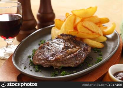 Grilled rib fillet steak with fried chips ready to serve.